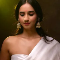 A portrait that captures the essence of traditional beauty with a modern sensibility. The warm lighting and rich tones highlight the intricate details of the jewelry and the subject's serene expression, making it ideal for ethnic fashion or personal branding.