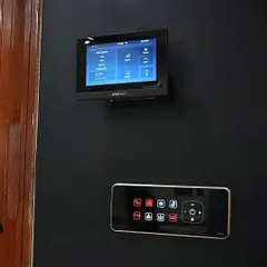 This is our integrated control setup, featuring a 'onetouch' wall monitor and a smart switch panel. The monitor displays video from the doorbell, while the panel provides tactile control over lights and other automated functions.