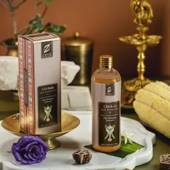 This styled shot for Zeva's 'Chi-kaa' body massage oil uses brass elements, fresh flowers, and natural stone to create a rich, earthy, and premium feel. The composition guides the eye from the packaging to the product itself.