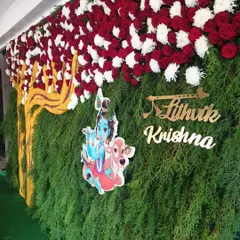 A side view of the Krishna-themed backdrop, showing the depth of the foliage and the placement of the custom nameplate.