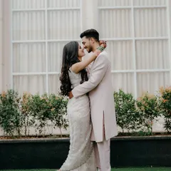 A full-length portrait showcasing their beautiful coordinated outfits and their happy, loving gaze. A perfect shot for an engagement announcement.