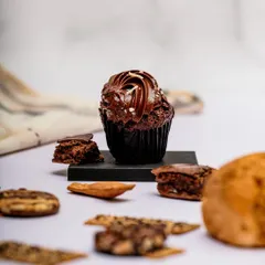 A styled shot of a chocolate cupcake, deconstructed with its ingredients around it. This tells a story about the quality of the ingredients and adds visual interest.