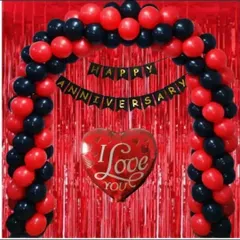 A classic anniversary decoration for an at-home celebration. This setup includes a red and black balloon arch over a red fringe curtain, with an 'Happy Anniversary' banner and a large 'I Love You' heart balloon.