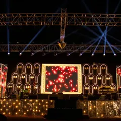 This image shows the versatility of the sangeet stage design. The combination of structural elements, truss lighting, and a central LED screen allows for a wide range of visual effects, from soft and romantic to bright and energetic.