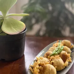A plate of hot, crispy Mini Vadas, a perfect savory snack, especially during the monsoon. I serve them with fried green chilies, just the way they are enjoyed back home.