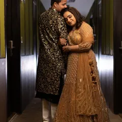 A beautiful portrait of our sangeet couple. The groom's classic black sherwani with intricate gold brocade work perfectly complements the bride's sparkling gold and orange lehenga. A truly stunning pair.