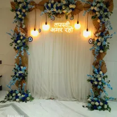 This blue and white themed decoration was for a Tapasvi event. I used a floral arch with dried palm leaves and a custom neon sign, along with evil eye charms for blessings.