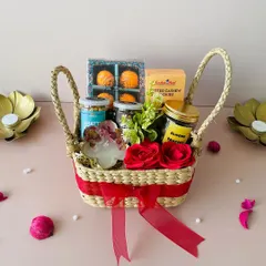 For a more rustic and eco-friendly touch, we offer hampers in sustainable Kauna grass baskets. This square basket is filled with treats like laddoo-shaped candles and healthy snacks, combining traditional charm with modern tastes.