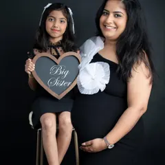 A proud big sister announcing her new role. Including older siblings is a wonderful way to make them feel special and excited about the new baby.