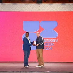 Capturing moments of recognition is a key part of our service. This photo shows an award being presented on stage at the UX Design Week, a critical shot for celebrating achievement and for use in press releases.