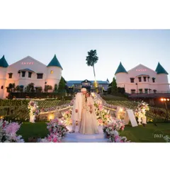 Another stunning shot of the couple at their hilltop wedding. The evening lights of the hotel create a warm, romantic glow, perfect for a destination wedding photograph.
