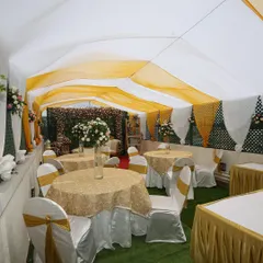 This is how we transform a space for a small gathering. The tent is elegantly draped in white and yellow, with coordinated table settings, creating a festive and cohesive look for a lockdown wedding.