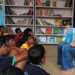 A volunteer reads to an engaged group of boys at our Kings of Castle Library. You can see the focus and curiosity in their eyes as they get lost in the narrative. These moments of shared imagination are where the healing happens.