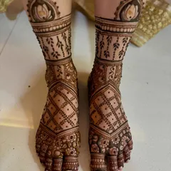 An intricate bridal feet design featuring lotus toppers, vine patterns, and a detailed grid work.