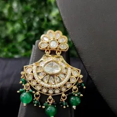 A classic chaand bali earring with green beads and a floral kundan top.