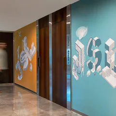 Custom graphics designed in partnership with Miller Ink adorn the walls near the washrooms at the Stainless Steel Office. These unique axonometric designs of the company's initials add a layer of bespoke branding to the space.