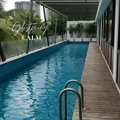 We designed this residential lap pool with a sleek wooden deck, creating a private oasis for exercise and relaxation. The design seamlessly integrates with the home's modern architecture.
