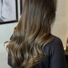 A beautiful example of brunette hair with subtle, natural-looking highlights. I styled it with soft waves to showcase the dimension and movement created by the color.