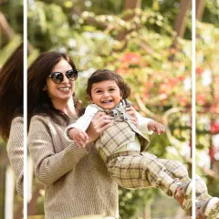 A mother joyfully lifts her laughing son in the air during their outdoor family photoshoot. The natural setting allows for spontaneous and playful interactions.