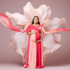 Here, I used a two-toned pink gown and flowing sashes to create a sense of movement and grace. The large floral backdrop complements the colors, resulting in a vibrant and joyful maternity photo.
