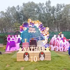 An elaborate outdoor K-Pop themed birthday party setup in Bangalore. This large-scale decoration includes a custom stage, light-up marquee letters, and life-sized cutouts of BTS and Blackpink band members.