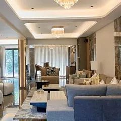 The living space of a neoclassic villa, where we blended timeless elegance with modern luxury. Every detail, from the multi-layered ceiling lighting to the curated material palette, is meticulously planned to create an atmosphere of sophisticated comfort and bespoke interior design.