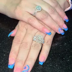 Modern, chic, and a little mystical. This design features a sharp blue French tip on a natural base, accented with a delicate evil eye and swirl art for a trendy and personalized style.