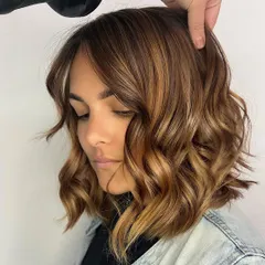 Caramel balayage brings a beautiful warmth and richness to the hair. This style features hand painted caramel highlights on a bob haircut, creating a customized look that reflects the client's personality and style.