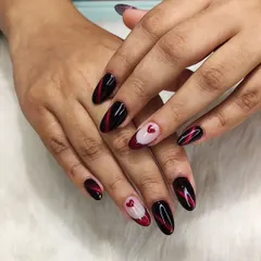 A design to die for. This look combines a dramatic red and black cat-eye effect with a delicate, hand-painted heart accent nail for a mix of bold and sweet.
