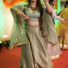 Our client looks absolutely radiant as she dances at her Mehendi ceremony. She is wearing a custom pastel green brocade lehenga with bell sleeves, designed for comfort, elegance, and movement.