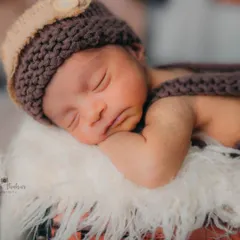 A tight close-up on the baby's peaceful, sleeping face. This shot is all about capturing the delicate features and serene expression of a brand new life.