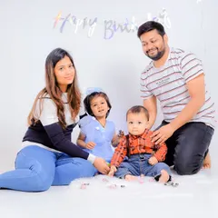 The whole family together for a first birthday studio photoshoot. I guide everyone into comfortable poses to get natural-looking group photos.
