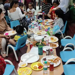 Time for snacks and cake! The kids are gathered around the table to refuel after an hour of play. We provide the space, you bring their favorite treats.