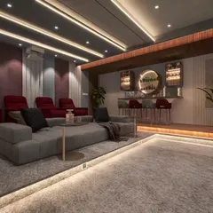 This entertainment space combines a home theater with a built-in bar at the back. The tiered seating and ambient floor lighting create a luxurious, cinema-like atmosphere.