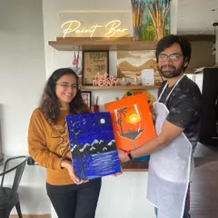 Another happy couple showing off their artwork. A painting date is a great way to connect, collaborate, and see a different side of your partner.