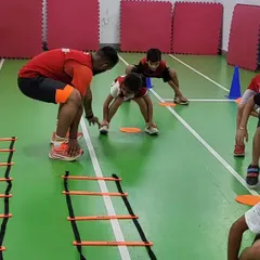Our coaches provide individual attention to help kids master the basics. Here, we're working on the correct squatting posture for agility drills, a fundamental skill for many sports.