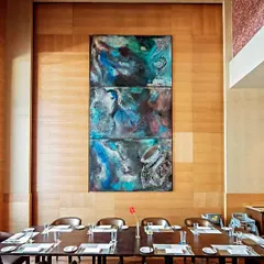 A stunning triptych by artist Adil Writer, titled 'Feast', displayed in a private dining area at the Sheraton. This demonstrates how we integrate art to elevate the ambiance of luxury hospitality spaces.