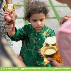 A child holds a platter of offerings during our festive welcome. These moments teach children about the rituals and significance of our cultural celebrations.