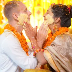 A tender moment amidst the fun. The couple gently applies haldi to each other, a sweet contrast to the usual chaos of the ceremony.