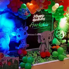A closer look at the adorable animal cutouts and neon sign for this jungle-themed birthday party. The vibrant lighting and detailed props create a fantastic photo opportunity for the little one.