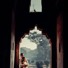 A beautifully framed shot of a couple in an archway at Lodhi Garden, Delhi. The dramatic shadows and historic architecture create a moody and timeless pre-wedding portrait.