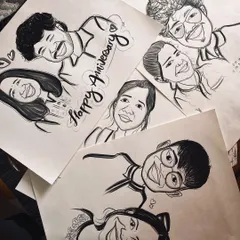 A flat lay of several recent commissions, including anniversary, couple, and solo portraits. So many happy faces in one picture.