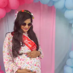 A "Mom To Be" enjoying her baby shower. The backdrop features a pink and blue balloon arch, perfect for gender reveal themes, creating a beautiful photo opportunity.