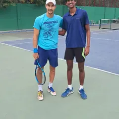 An on-court photo of our player Parth with ATP pro Tristan Boyer, an invaluable opportunity to learn from a professional.