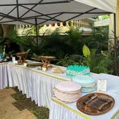 Here is a glimpse of my buffet setup under a canopy for an outdoor garden party. I provide everything needed, including tables, linens, and serving ware, for a clean and professional look.