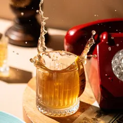 Capturing the splash. This dynamic action shot freezes a moment in time, adding energy and excitement to a simple whiskey on the rocks.