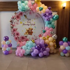 The 'We Can Bearly Wait' theme is a client favorite for baby showers. This design includes a custom printed backdrop with cute teddy bears, surrounded by a circular balloon arrangement in a mix of soft pastel colors.