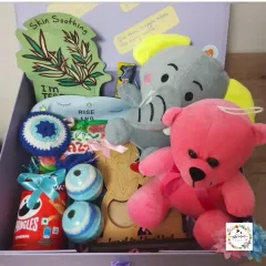 I designed this baby shower hamper to pamper the mom-to-be. It's packed with skin-soothing essentials, cute plush toys for the baby, snacks for her cravings, and personal touches like a crocheted evil eye charm for good luck.