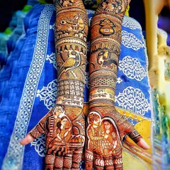 This full bridal design showcases a variety of storytelling elements. It includes portraits of the couple, figures of deities, and symbolic motifs, all tied together with intricate patterns.