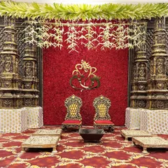 For a truly royal feel, I designed this mandap with a rich red floral backdrop, ornate golden chairs, and traditional pillars, evoking the grandeur of a palace.